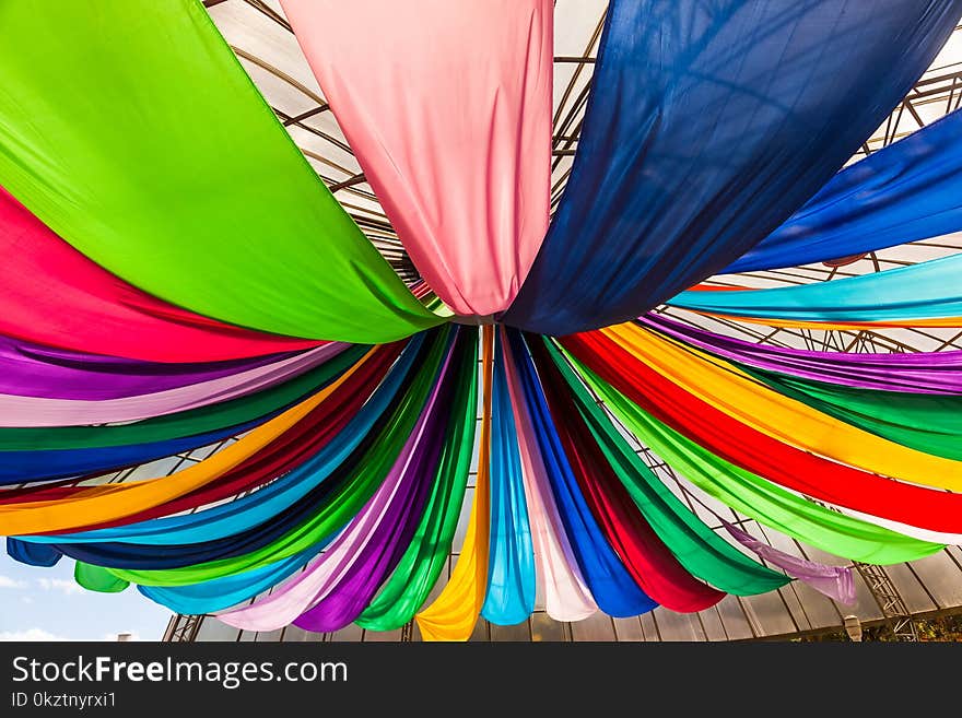 Fabrics of various colors hanging from a ceiling