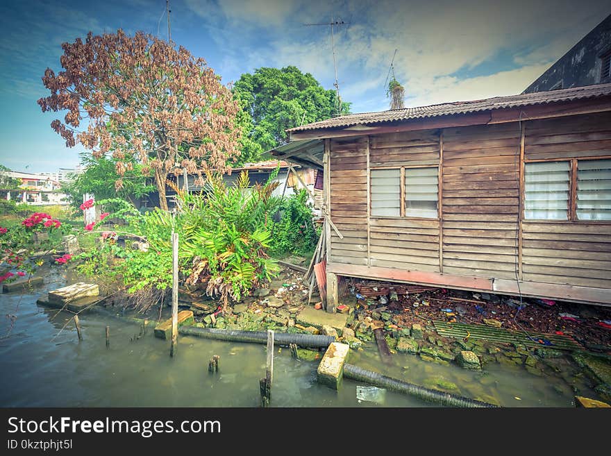 Vintage tone close-up old shack slum house near Malacca river. Old wooden hut on stiltson the bank of river in Melaka. Vintage tone close-up old shack slum house near Malacca river. Old wooden hut on stiltson the bank of river in Melaka