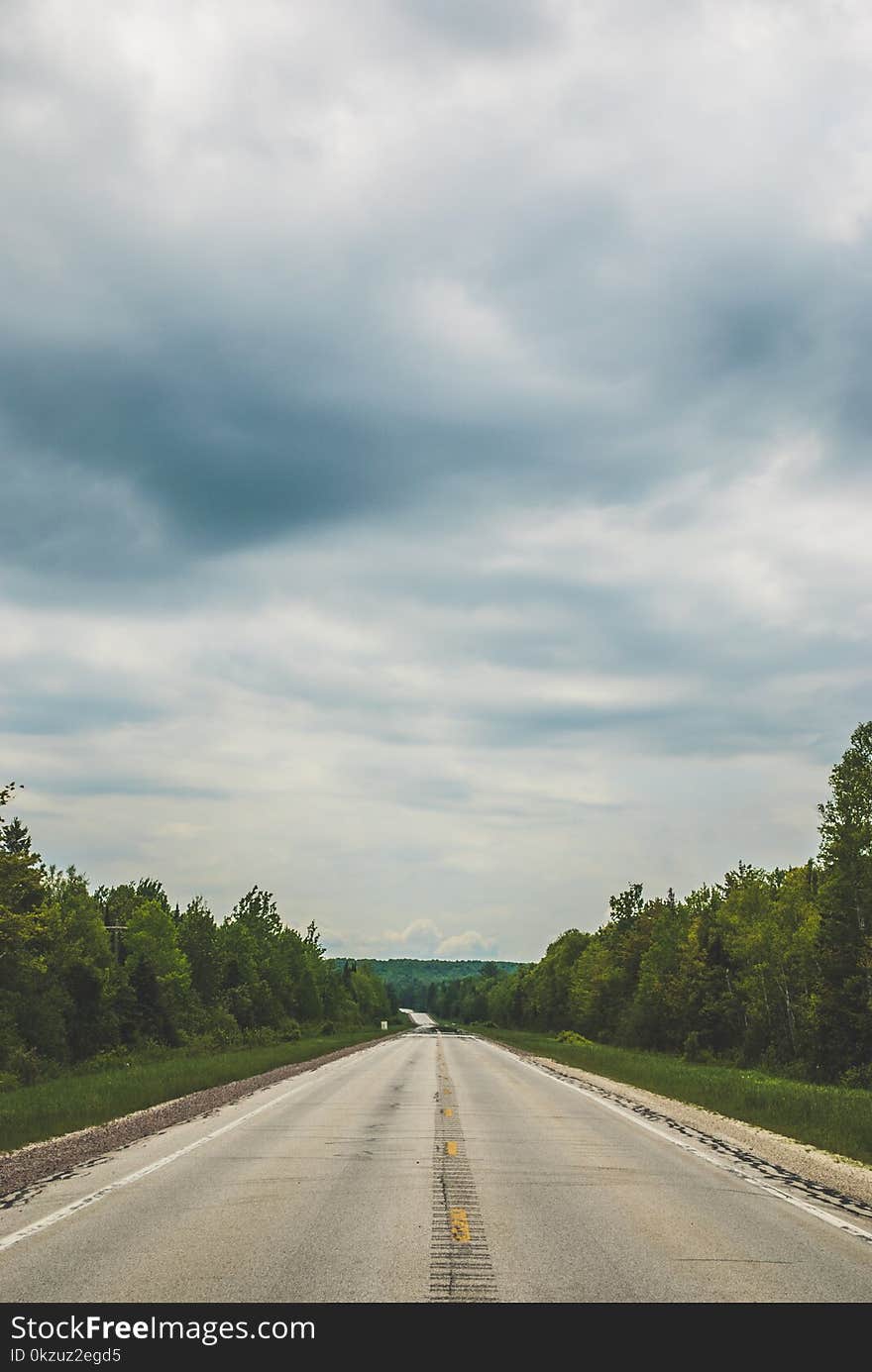 Empty Blacktop Road Under Cloudy Sky