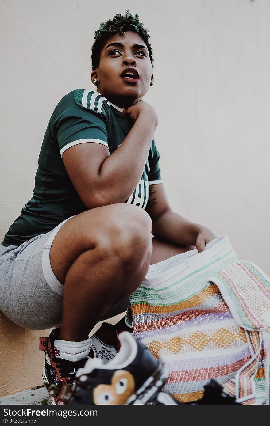 Woman Wearing Green Jersey Holding Multicolored Towel