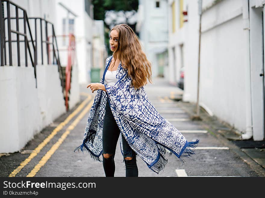 Woman Walking on Gray Pave Rod Near Building