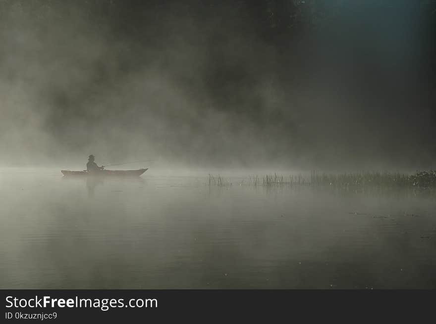 Person Riding Boat on Body of Water