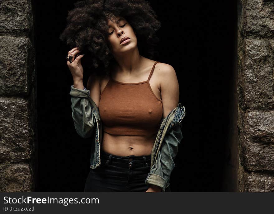 Woman in Brown Crop Top Standing Between Concrete Walls