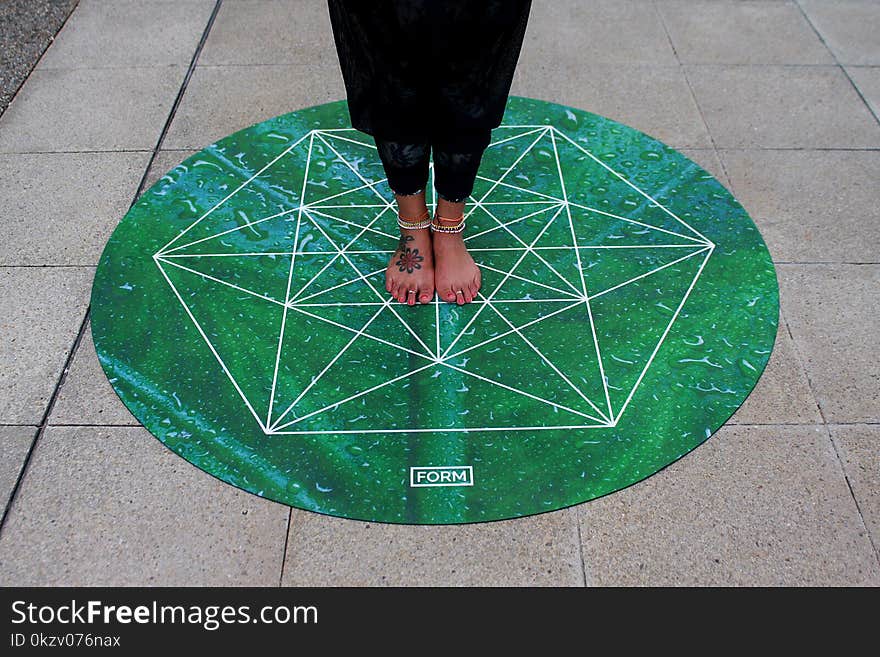 Person Standing on Green Round Mat