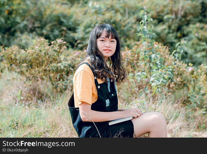 Shallow Focus Photography of Woman in Yellow Shirt and Black Dungaree