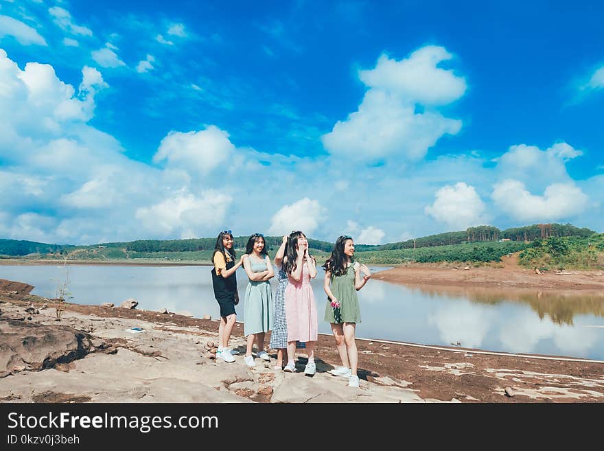 Four Women Standing Near Lake