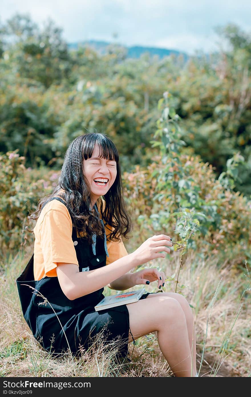 Woman Wearing Black Romper Sitting on Grass