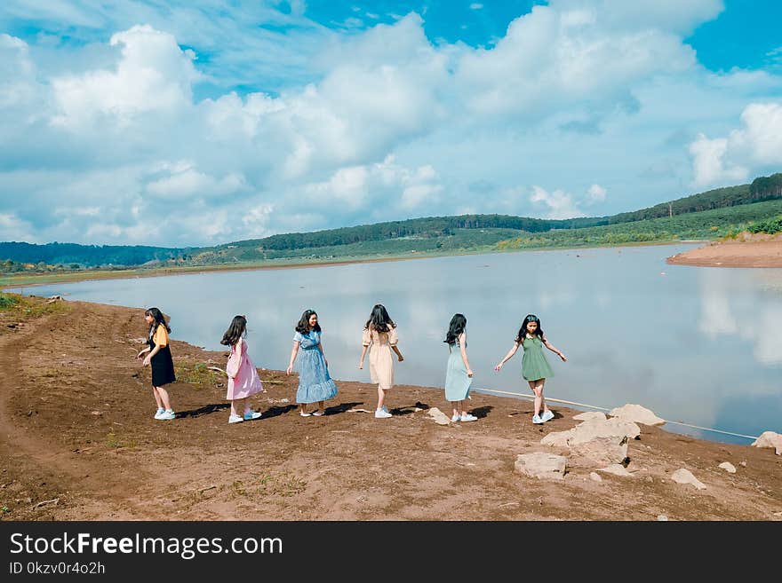 Six Girl Standing Beside Body of Water