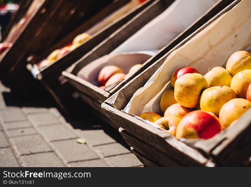 Yellow and Red Apples on Brown Crate