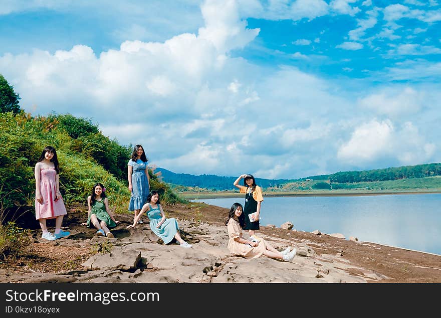 Women Sitting Near Body Of Water