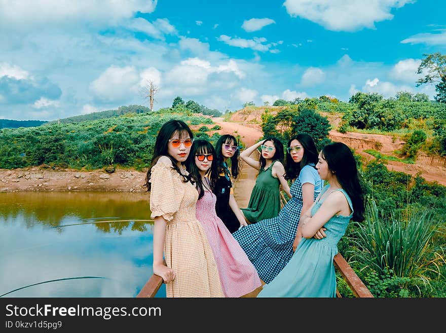 Photo of Six Woman Sitting on Dock Fence