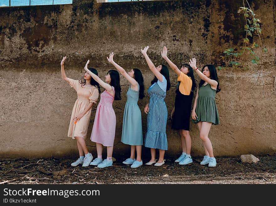 Group of Women Standing Infront of Brown Wall