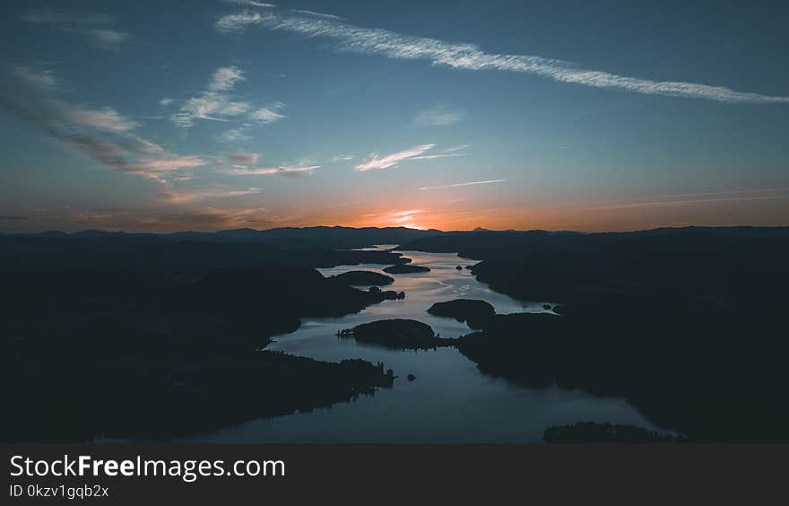 Aerial Photography of Water Beside Forest during Golden Hour