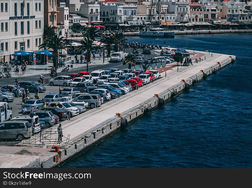 Cars Parked Near Buildings and Body of Water