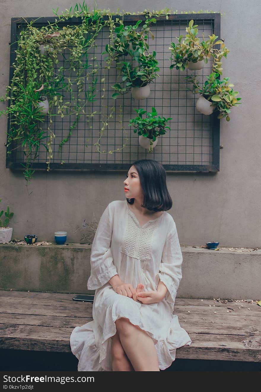 Woman In White V-neck Long-sleeved Dress Sitting On Bench