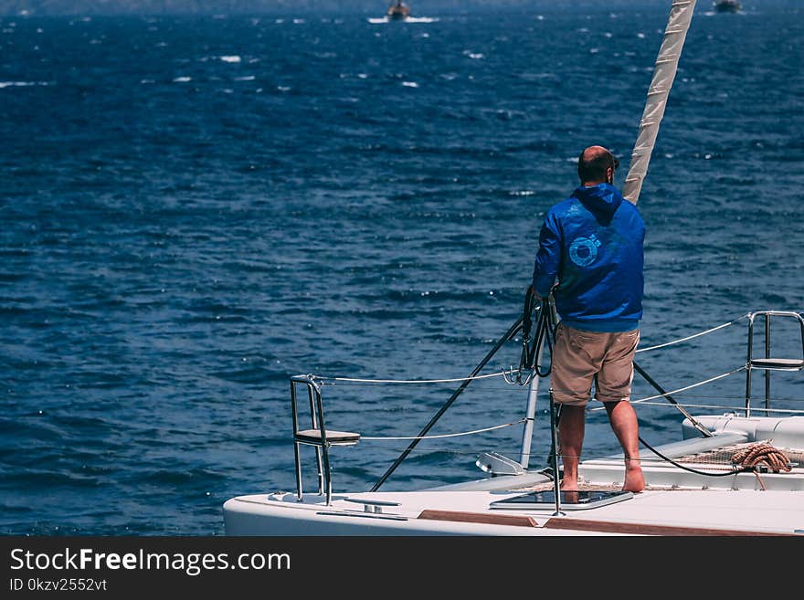 Man in White Hooded Jacket Riding on Boat