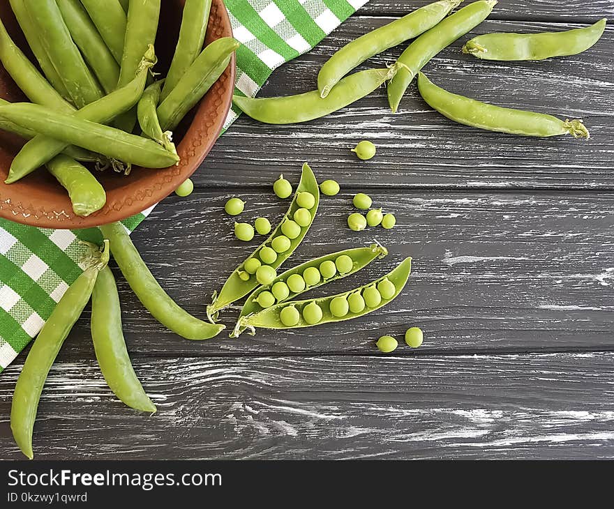 Fresh green peas vitamin on a black wooden background