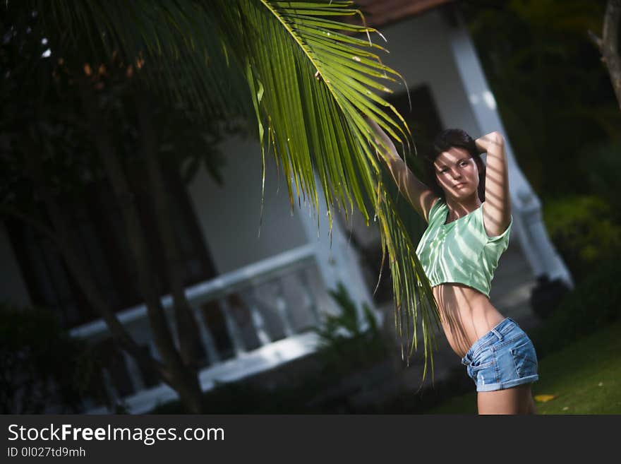 Young Beautiful Girl Posing With Palm Leaf