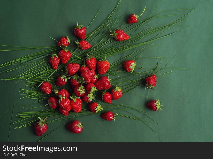 Bright red strawberry on a green background. Top view.