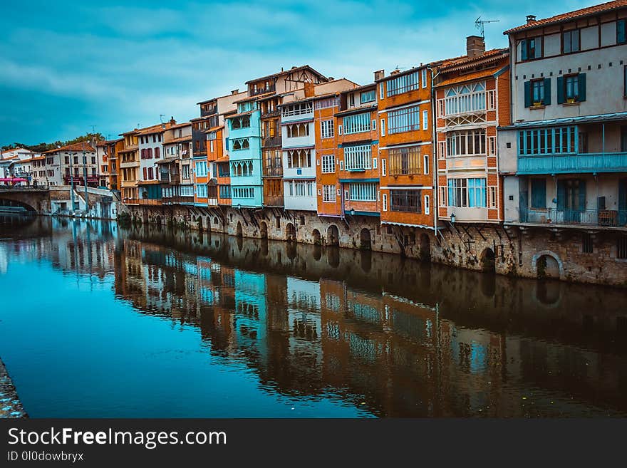 Assorted-color Concrete Buildings Beside River at Daytime