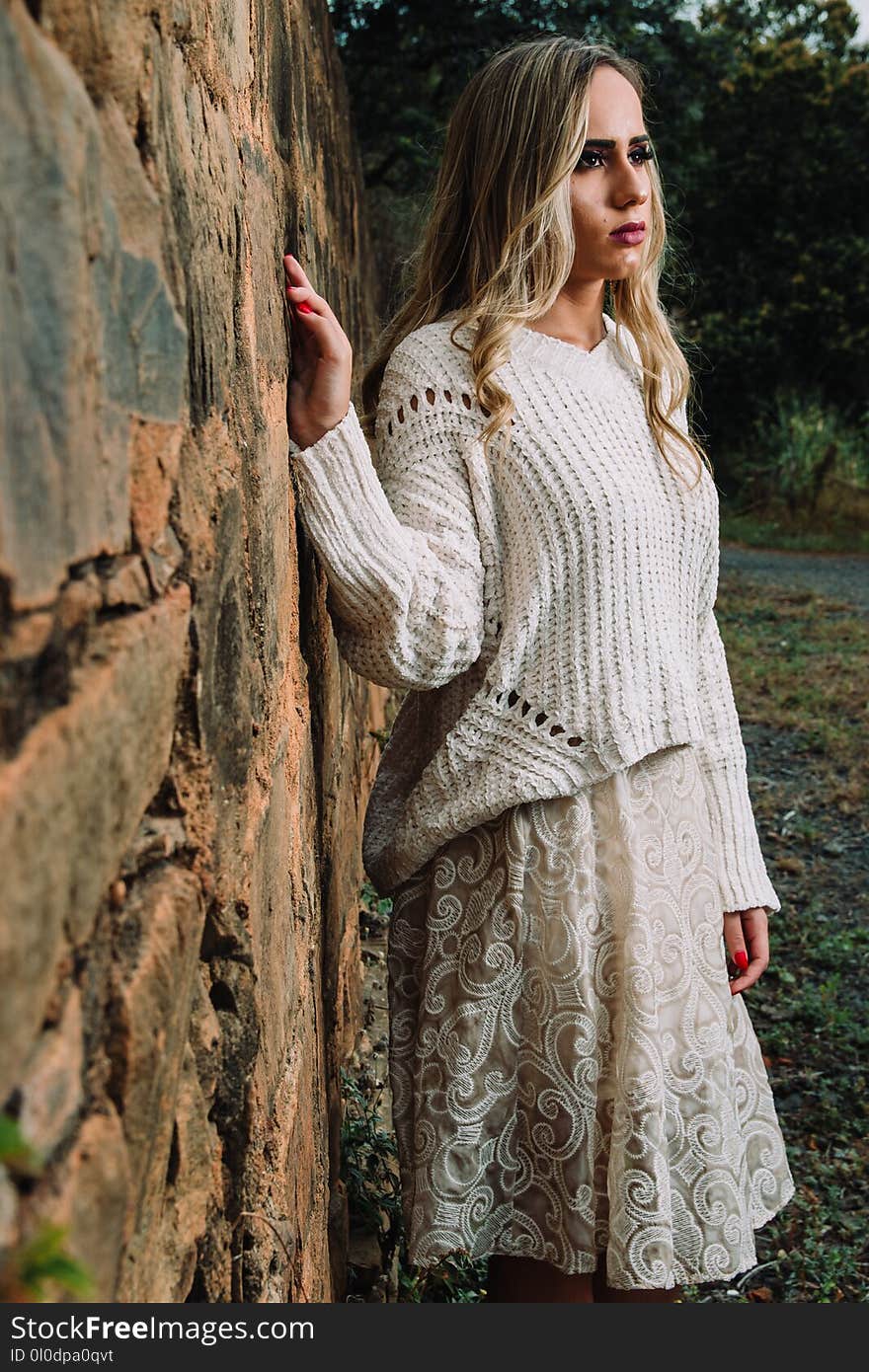 Woman in Knitted V-neck Long-sleeved Shirt and Midi Skirt Standing Beside Wall