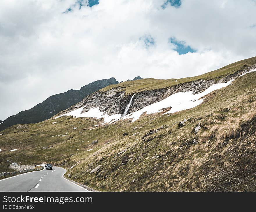 Asphalt Road Beside Green Hills at Daytime