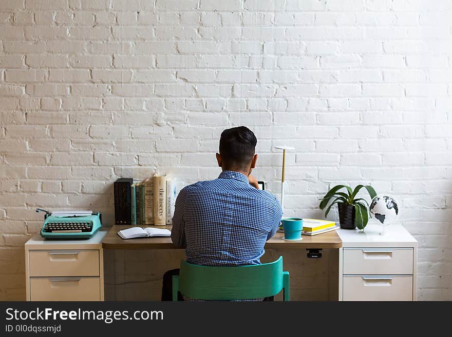 Man Sitting in Front of White Table