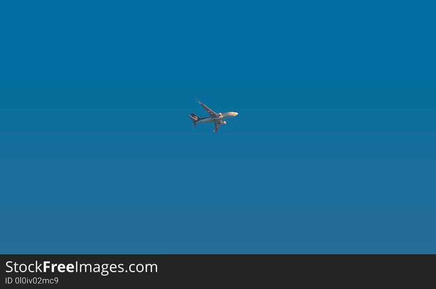 An airplane in a beautiful sunny day of winters and vibrant blue sky in background. An airplane in a beautiful sunny day of winters and vibrant blue sky in background.