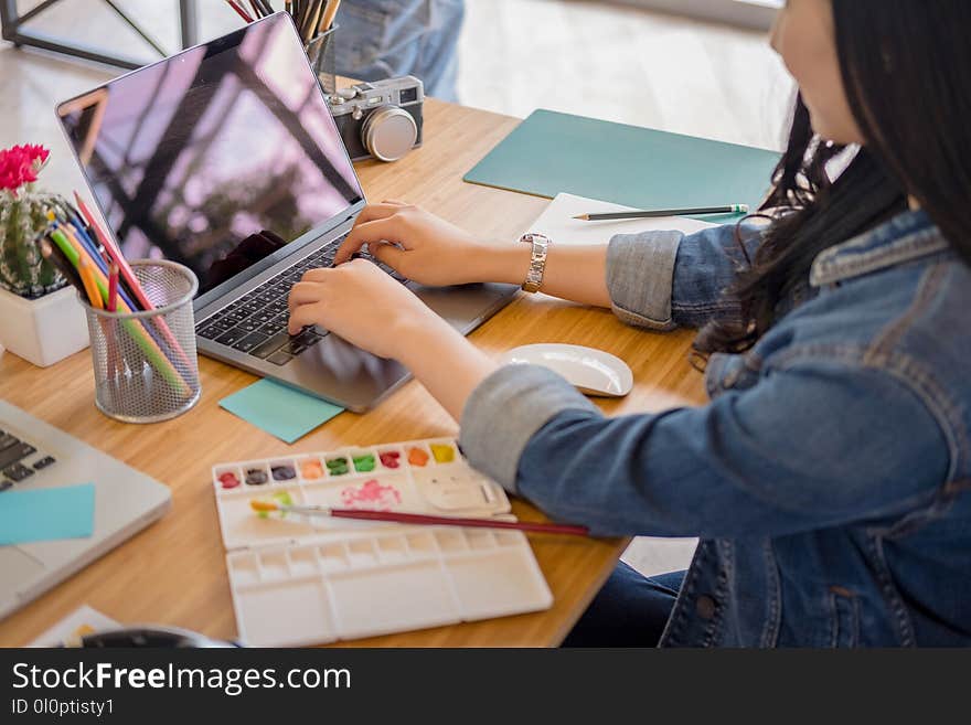 Woman Using Black Laptop While Leaning on Brown Wooden Table