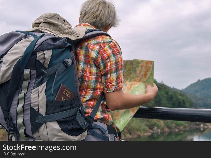 Man Holding Green and Brown Map