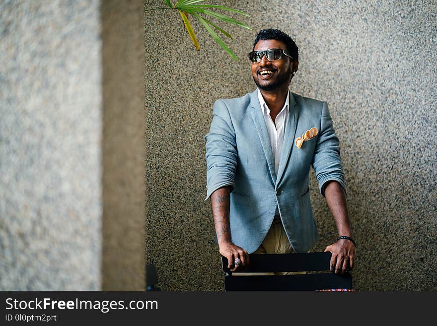 Man in Blue Formal Jacket in Front of Black Wooden Chair