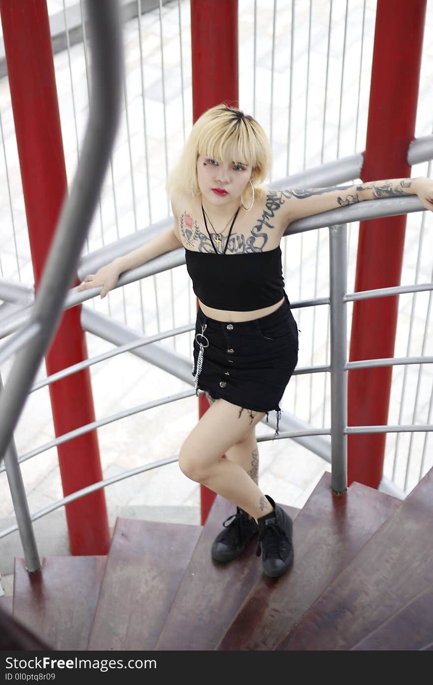 Photo of Woman Leaning on Gray Handrail