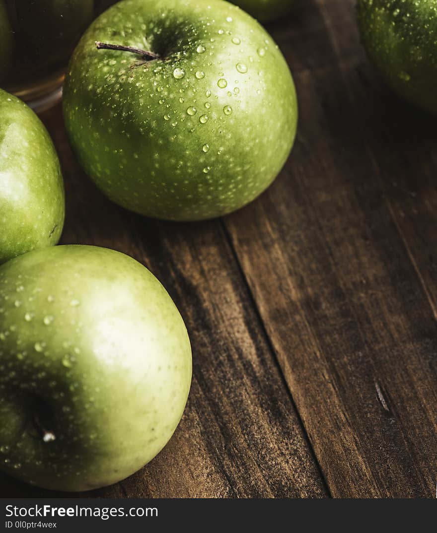 Green Apples on Brown Surface