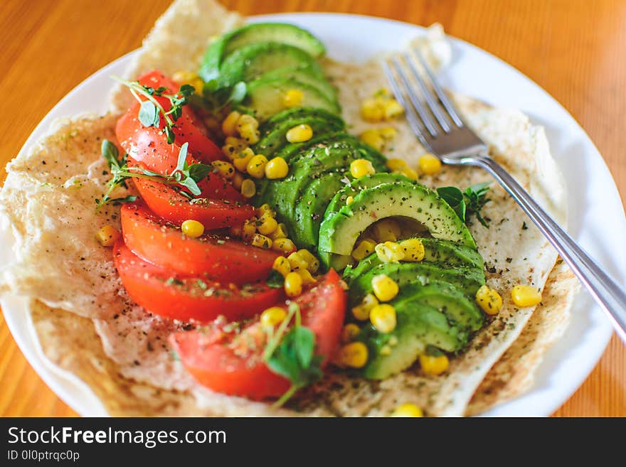 Sliced Tomato and Avocado on White Plate