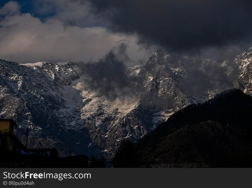 Snowy Mountain Peaks Under Cloudy Sky