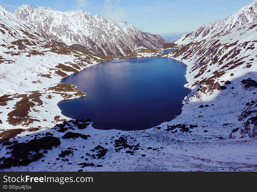 High-angle View of Body of Water in Between Snow-covered Mountain Range