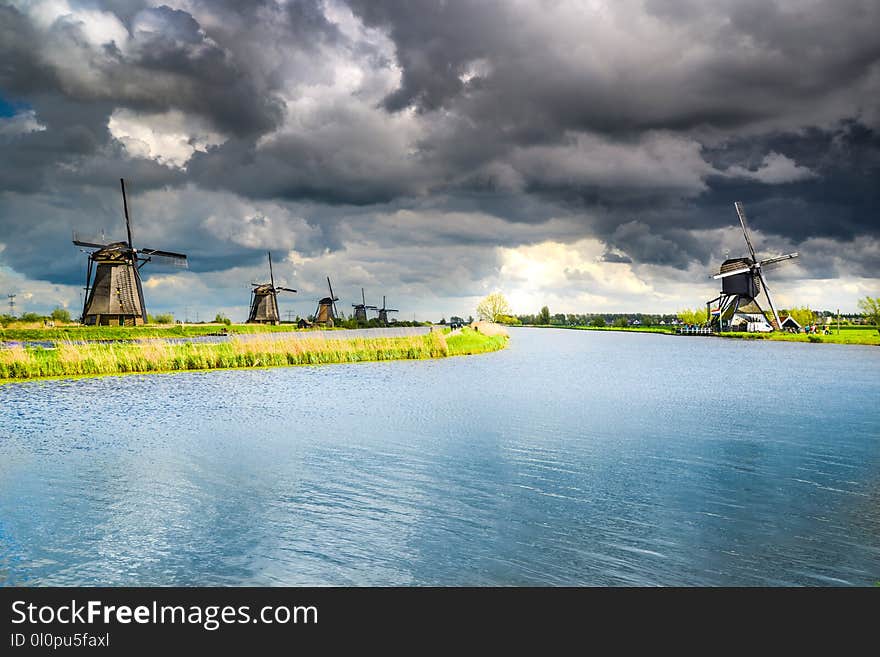 Wind Mills Near Body of Water