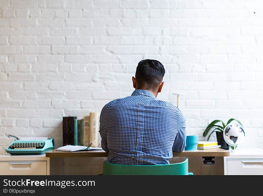 Man Sitting on Chair Facing Table