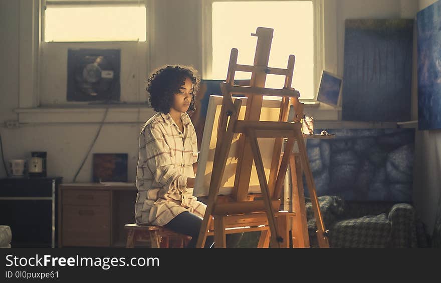 Photo of Woman Painting in Brown Wooden Easel