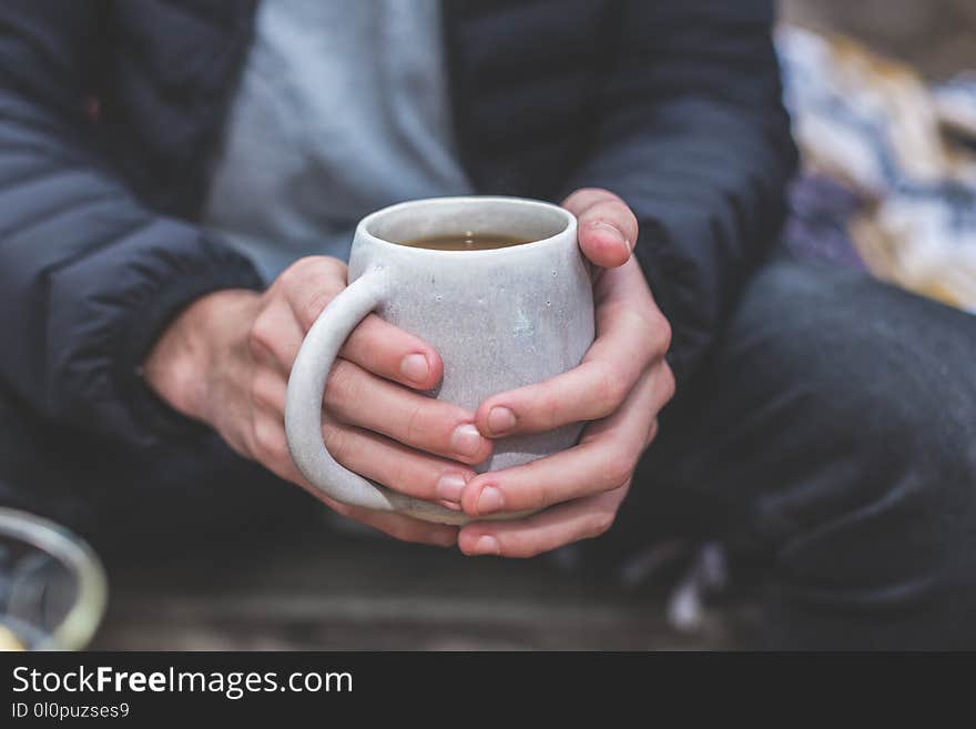 Shallow Focus Photography of a Person Holding White Ceramic Mug