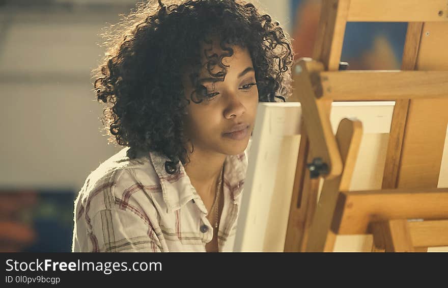 Woman Wearing White Collared Shirt Standing Near Brown Easel