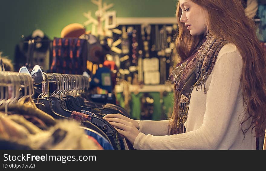 Woman Wearing White Long-sleeved Shirt With Scarf Standing Near Clothes