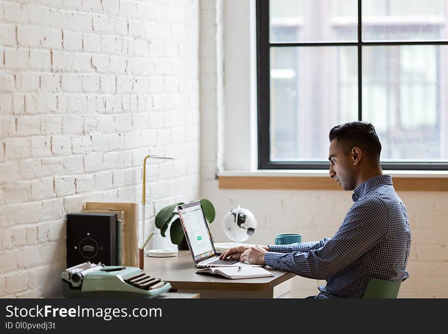 Man Sitting on Green Chair While Using Laptop