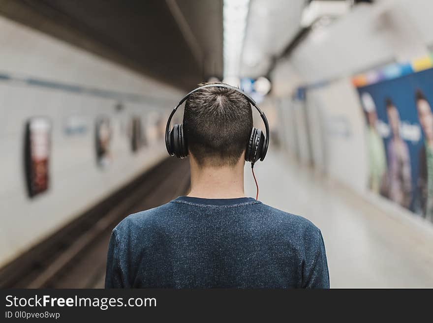 Man Wearing Black Headphones Beside Train Rail