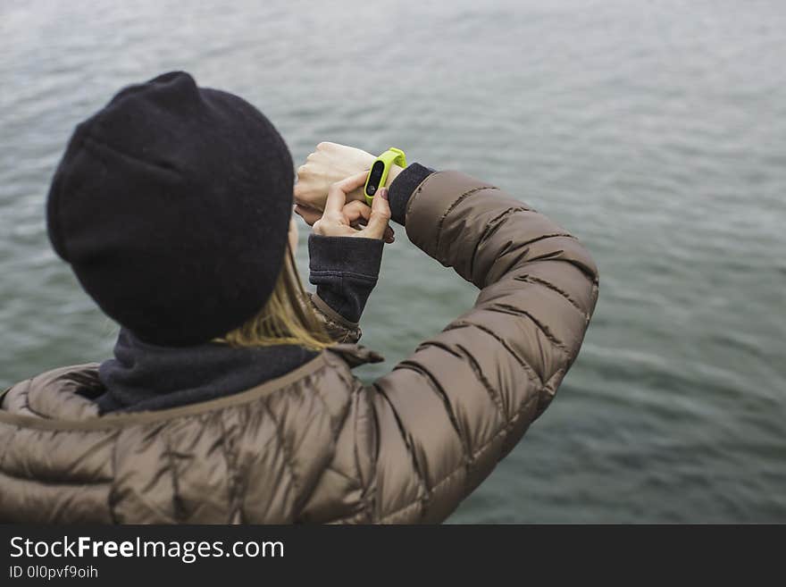 Woman Looking at Black and Yellow Activity Tracker