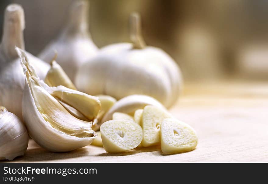 Cloves garlic and whole garlic on the wooden table.