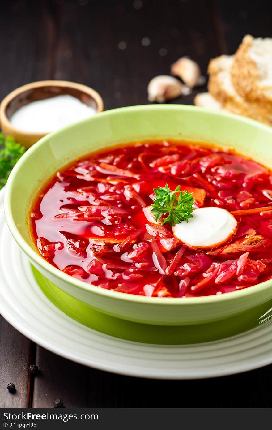 Borsch - traditional Ukrainian and Russian beetroot soup on dark wooden background. Selective focus.