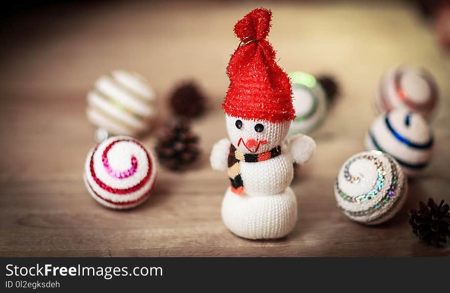 Toy snowman and gingerbread house at the Christmas table