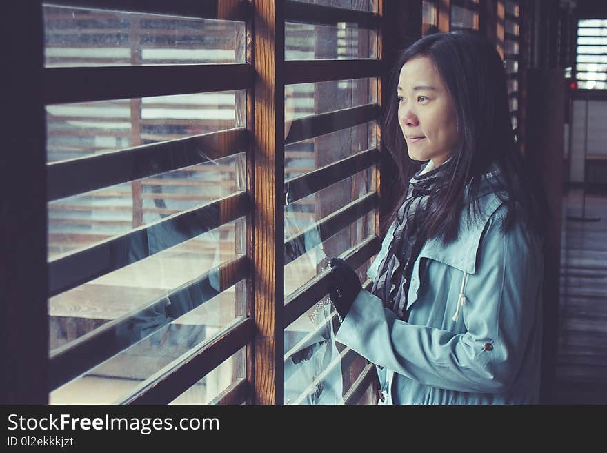 Asian woman standing ion wooden floor in Japanese Castle and looking to outside. Selective focus