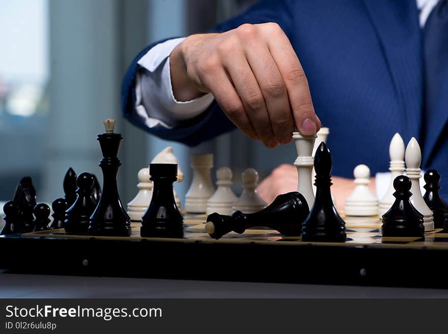 The businessman playing chess in strategy concept